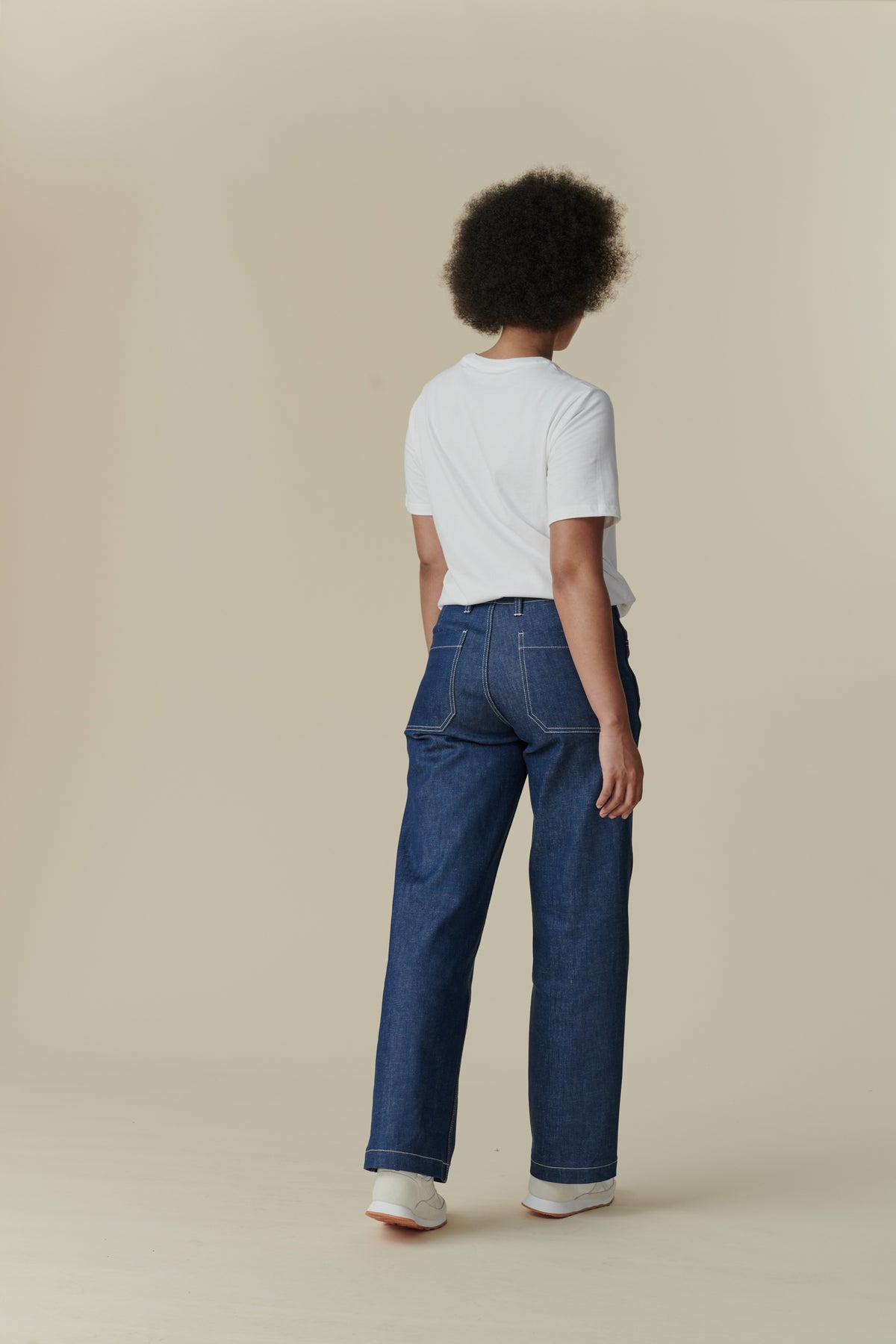 Female wearing white crew neck white t shirt paired with women's work jean in Blue, white contrast stitching