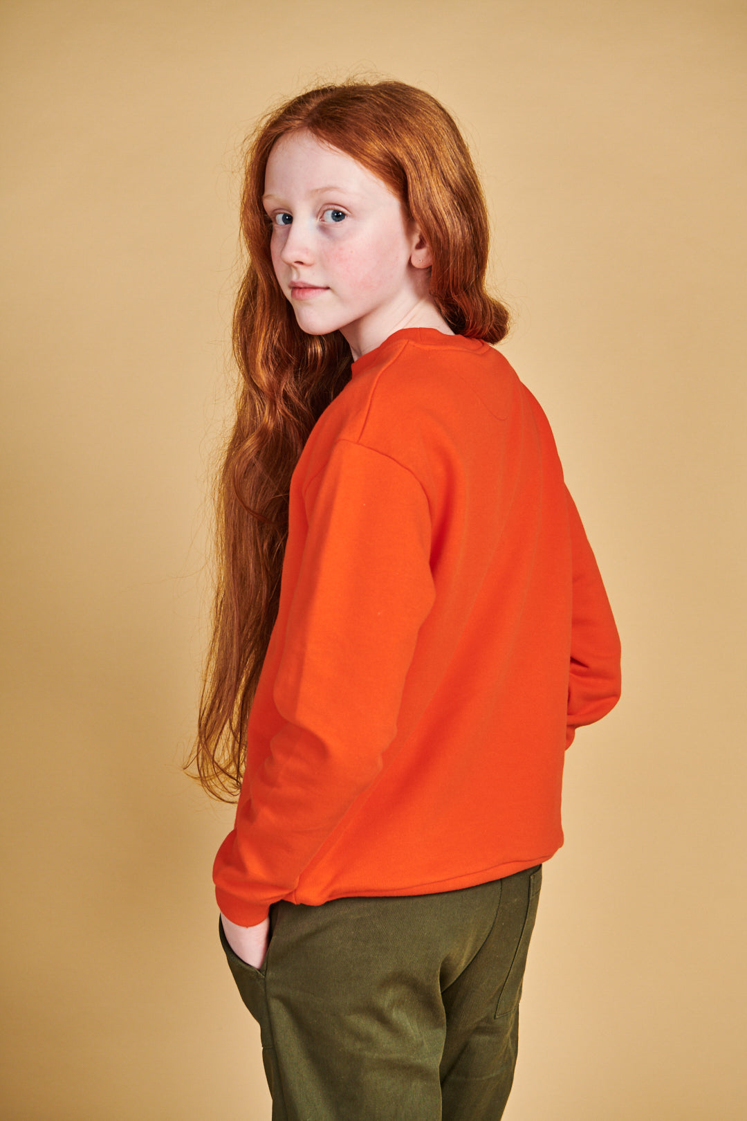 Boy wearing plastic free sweatshirt in flame red with Boffles print on front