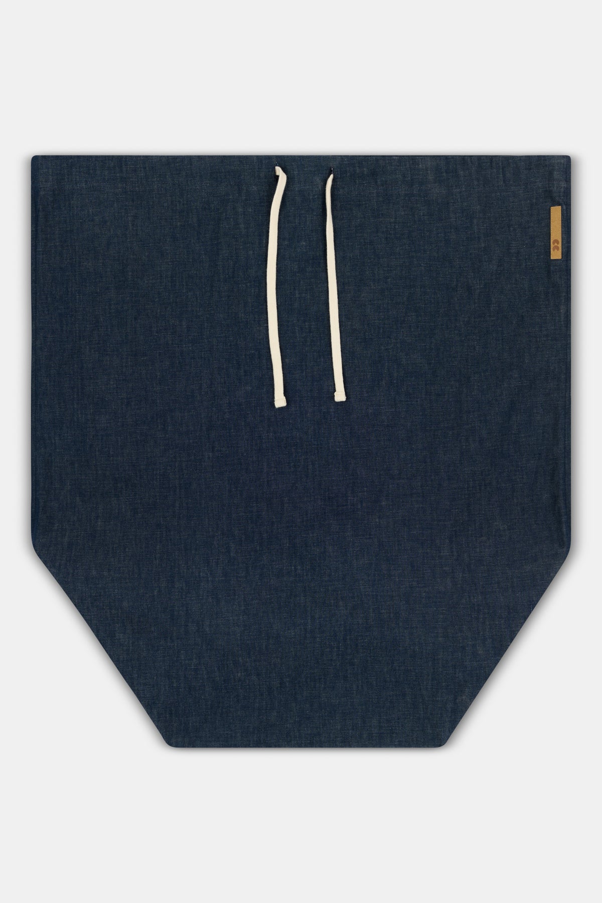 Flatlay of large laundry bag made from deadstock lightweight denim with cc logo patch and ecru drawcord 