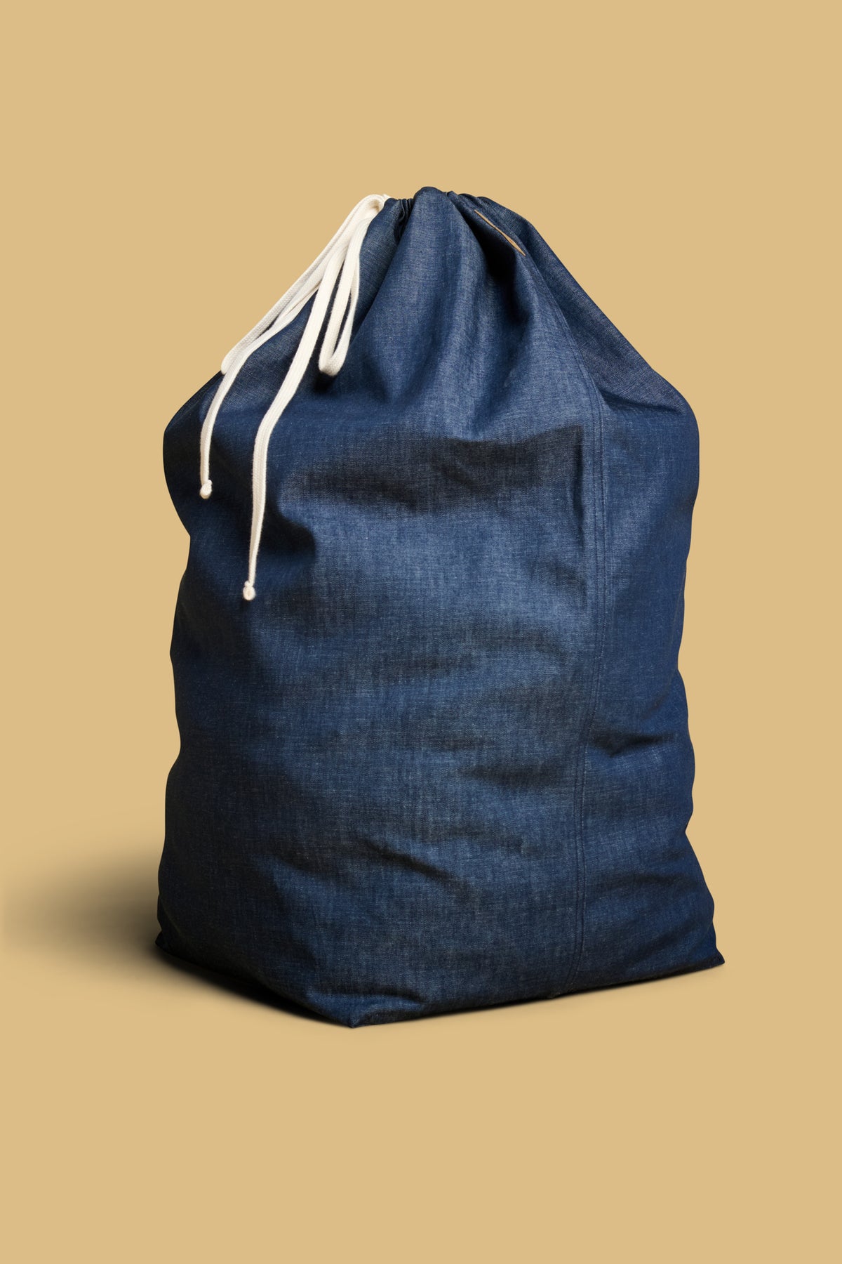 Large laundry bag made from deadstock indigo denim with ecru drawcord.