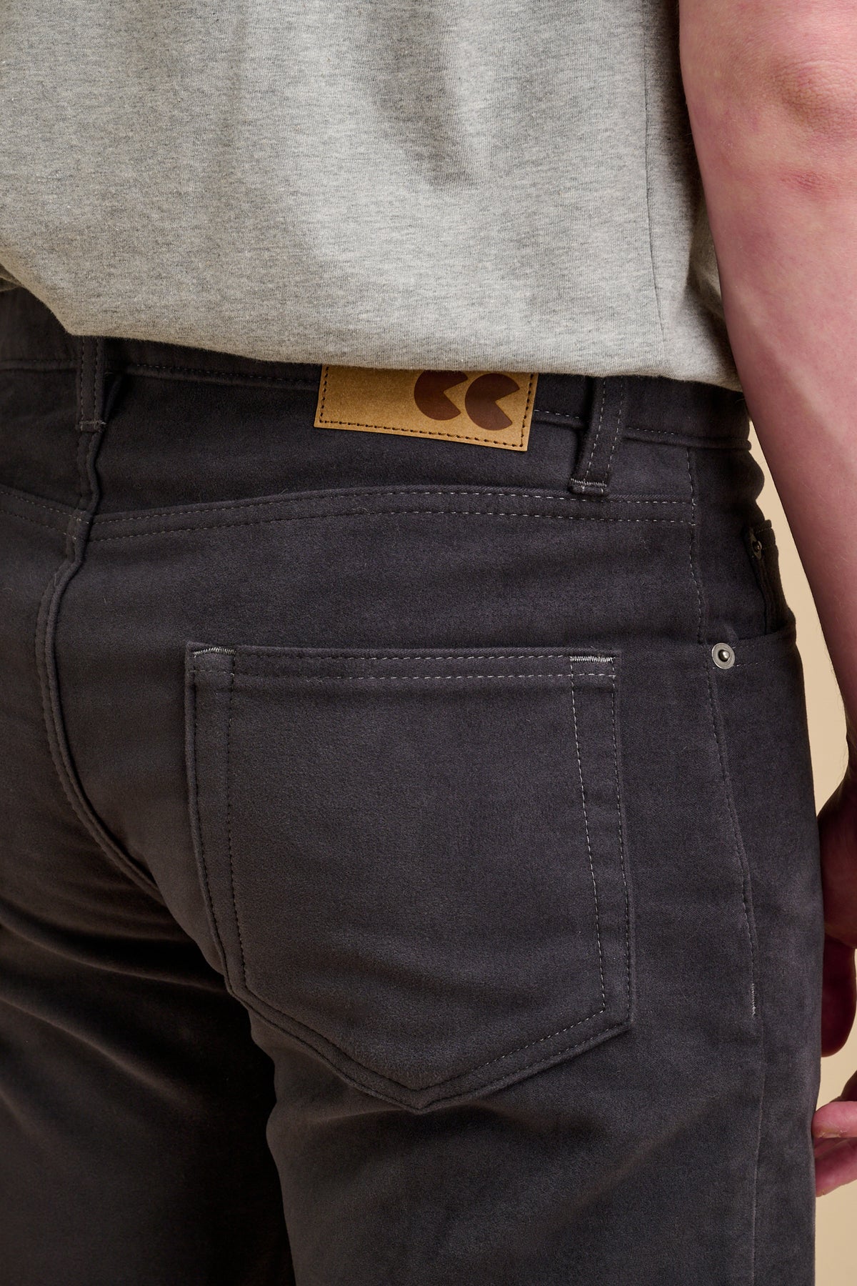 Close up of the back of male wearing moleskin jeans in slate grey with CC jeans patch.