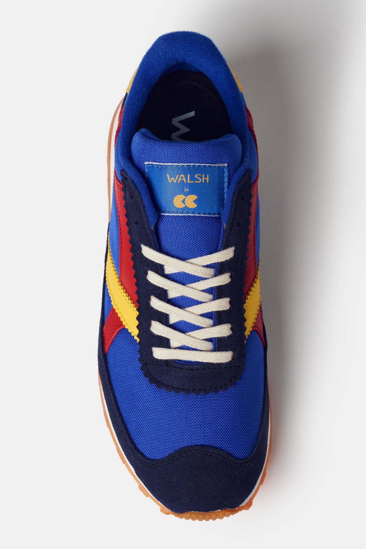 Men's Beacon Trainer in blue. White laces with red and yellow side design. Walsh X CC tongue logo label 