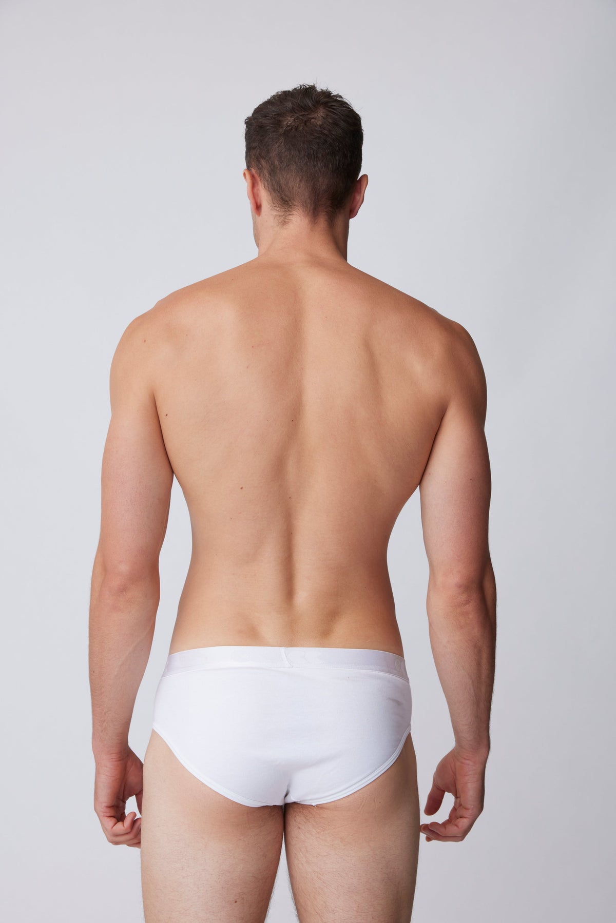 black male facing away showing the back of  white underwear brief 