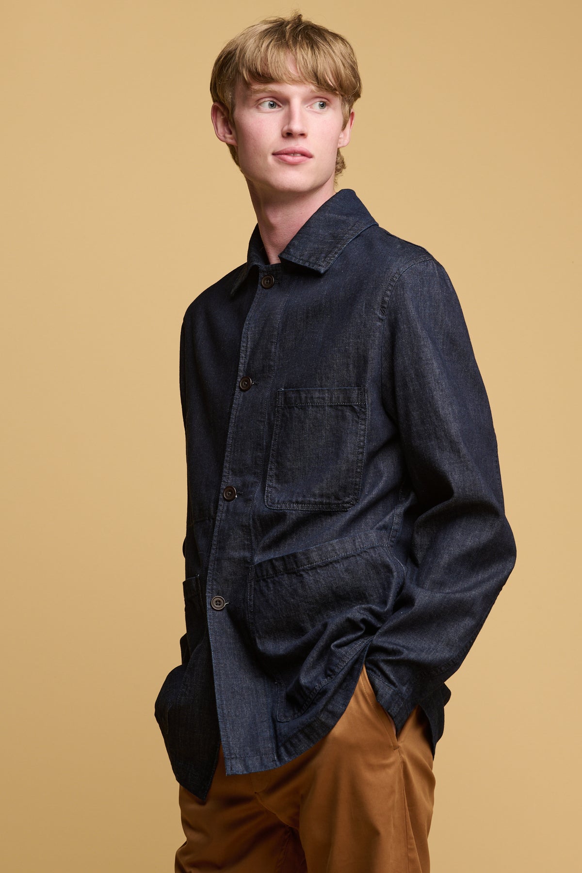 thigh up of male wearing indigo denim in chore jacket