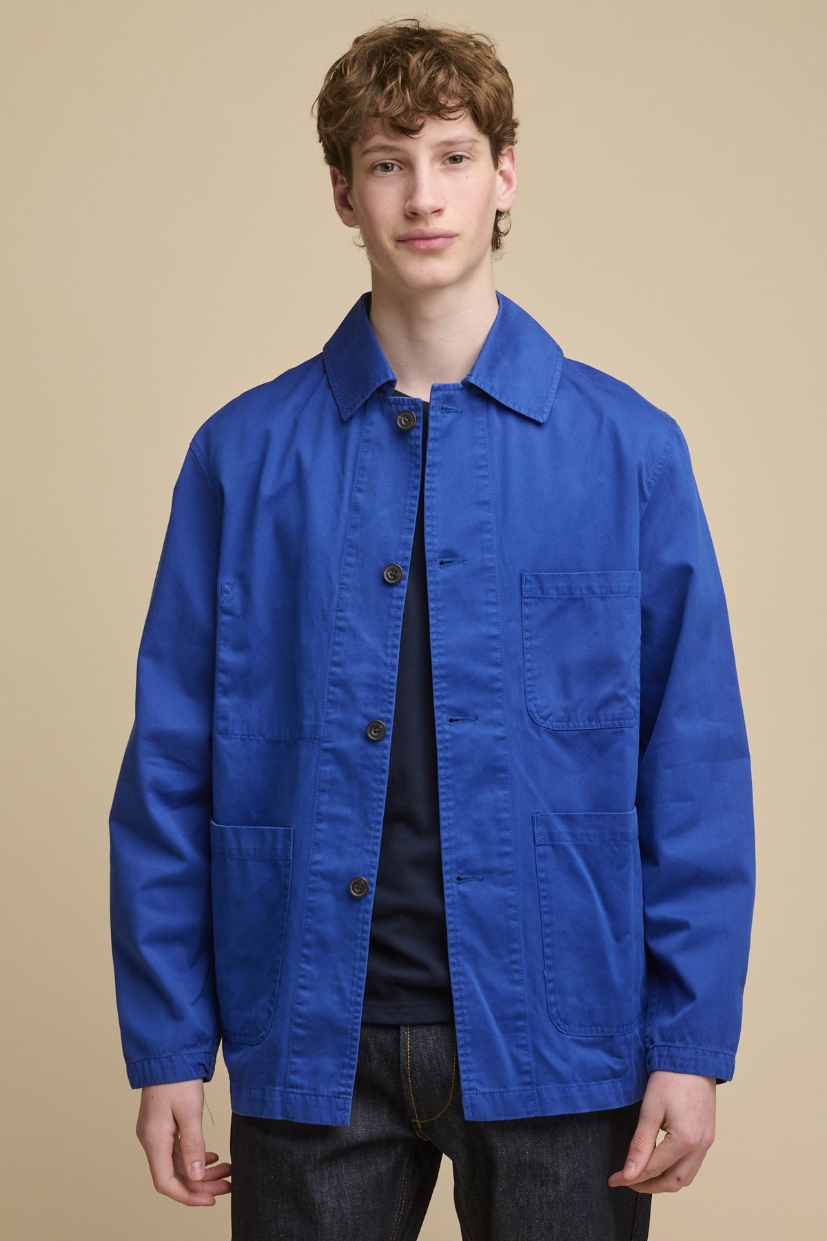 Male wearing washed royal blue chore jacket over navy t shirt
