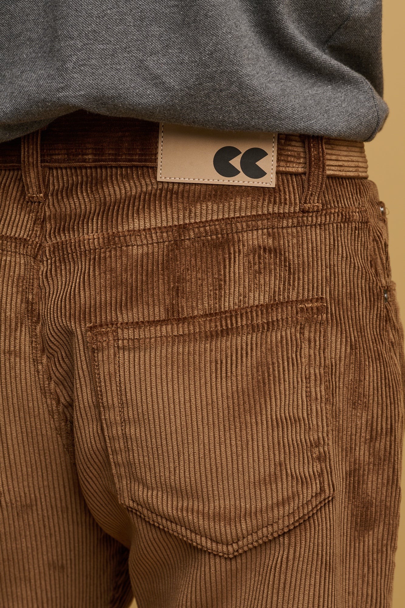 The front of male waist down wearing cord trousers in tan