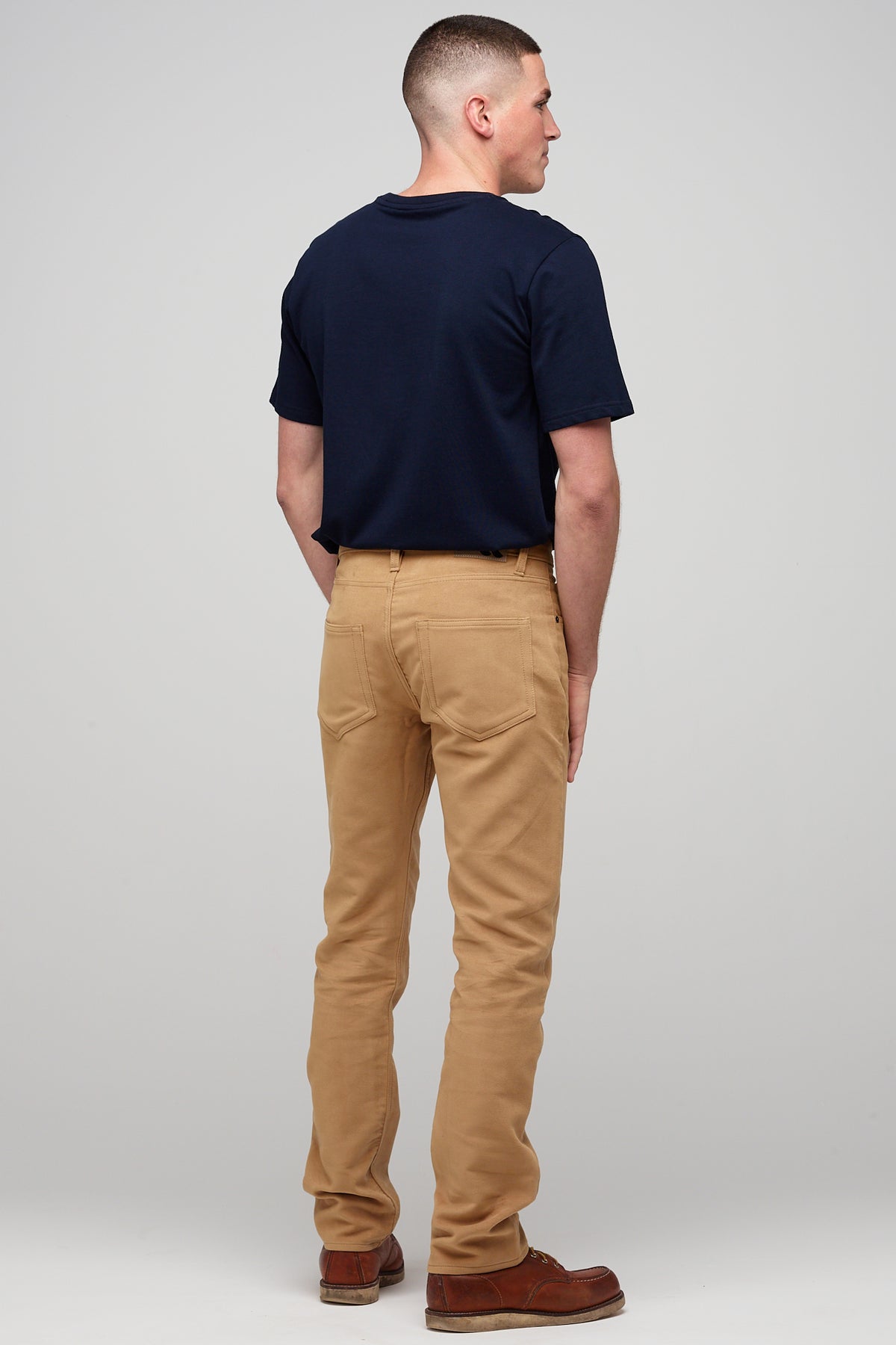 Male brunette wearing five pocket moleskin jeans in camel styled with black t-shirt