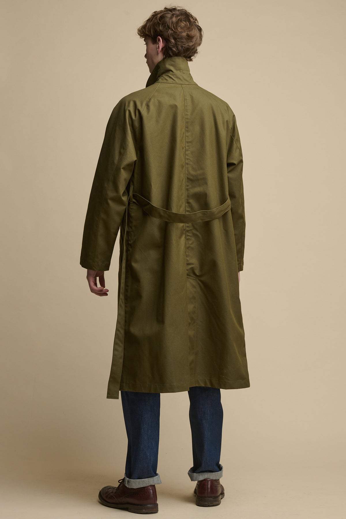 The back of men's Frank Raglan Raincoat in olive with collar up