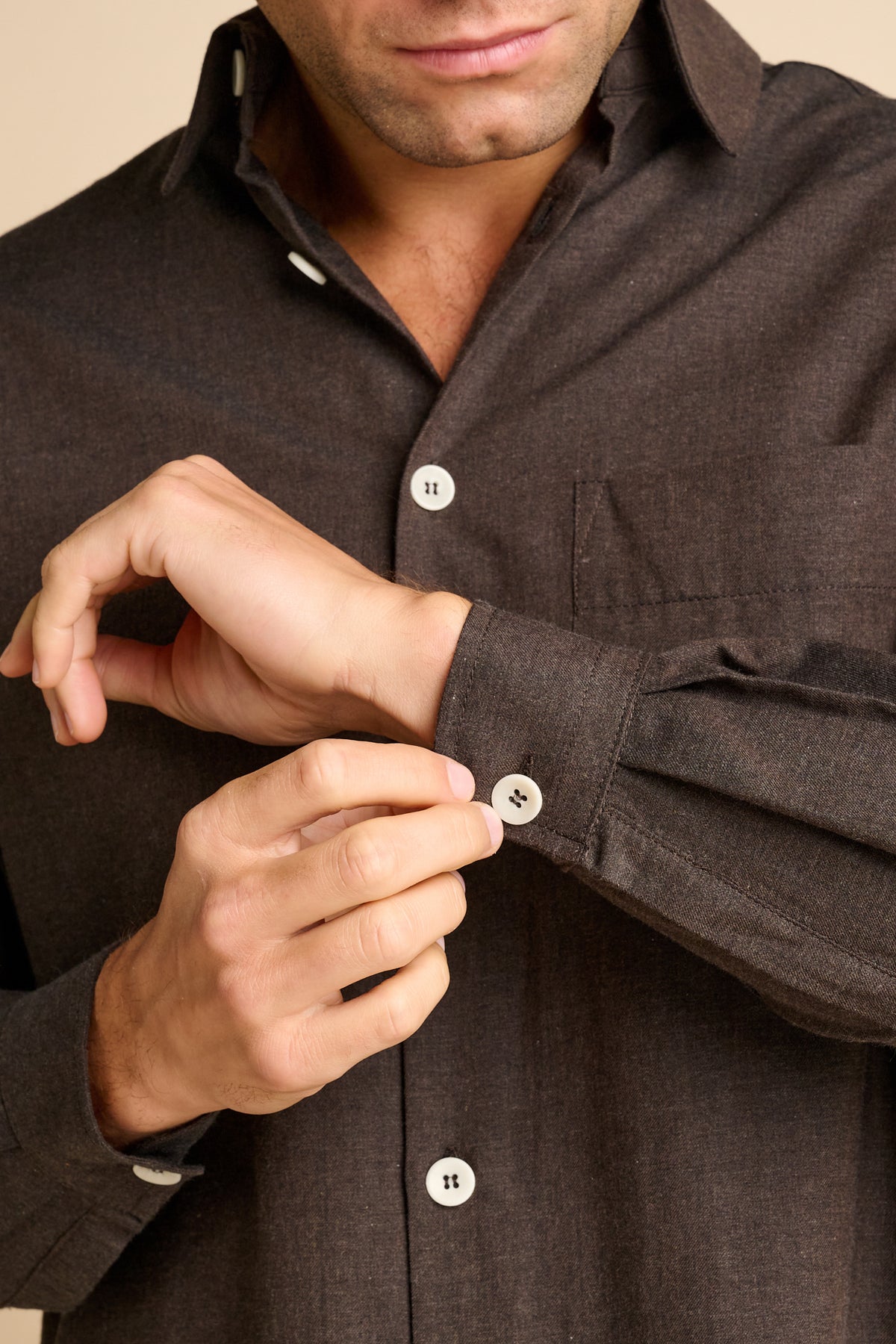 Man wearing brown shirt showing cuff detail.