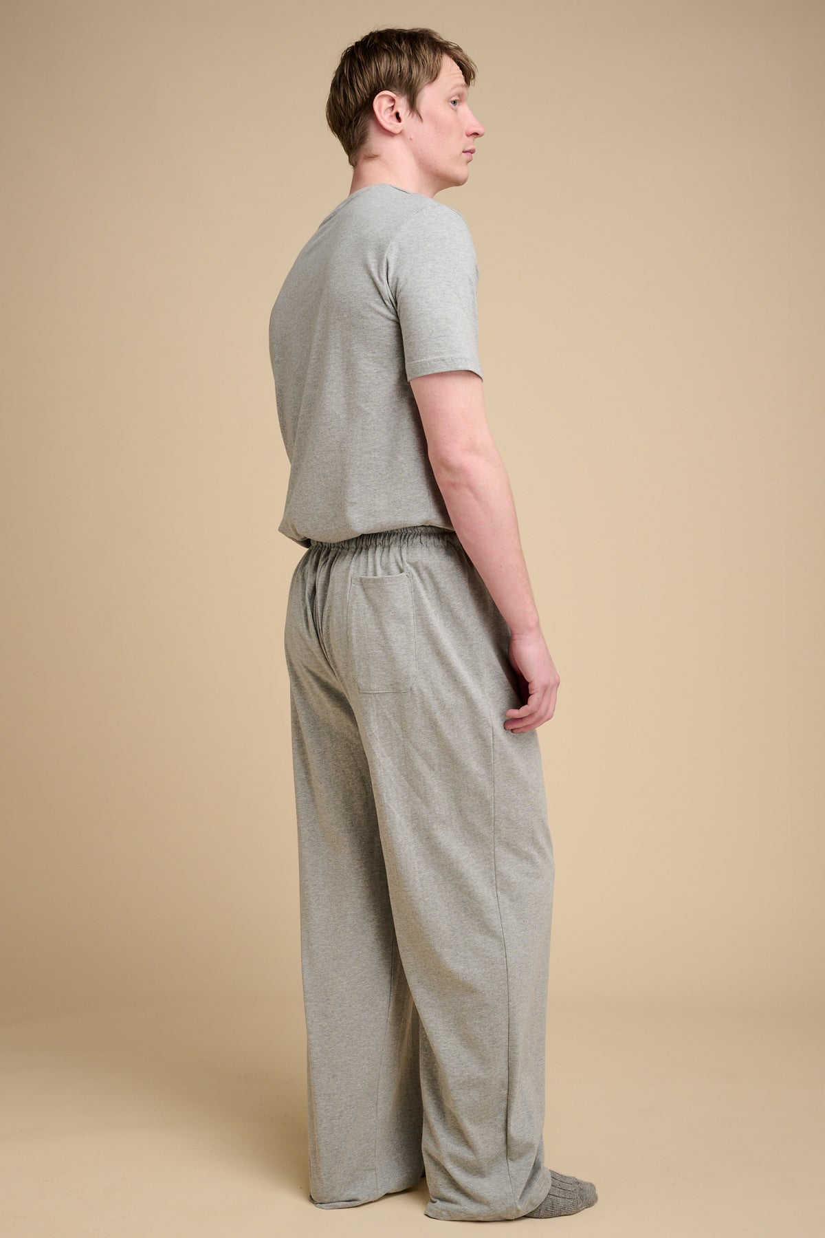 The back of male wearing grey marl pyjamas with back pocket.