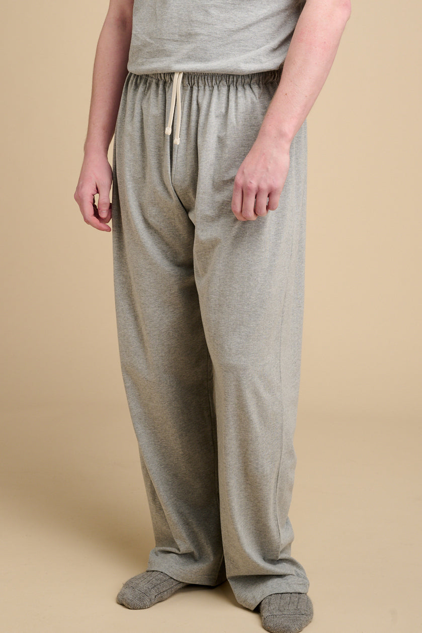 Waist down of male wearing grey marl pyjama bottoms with ecru drawcord.