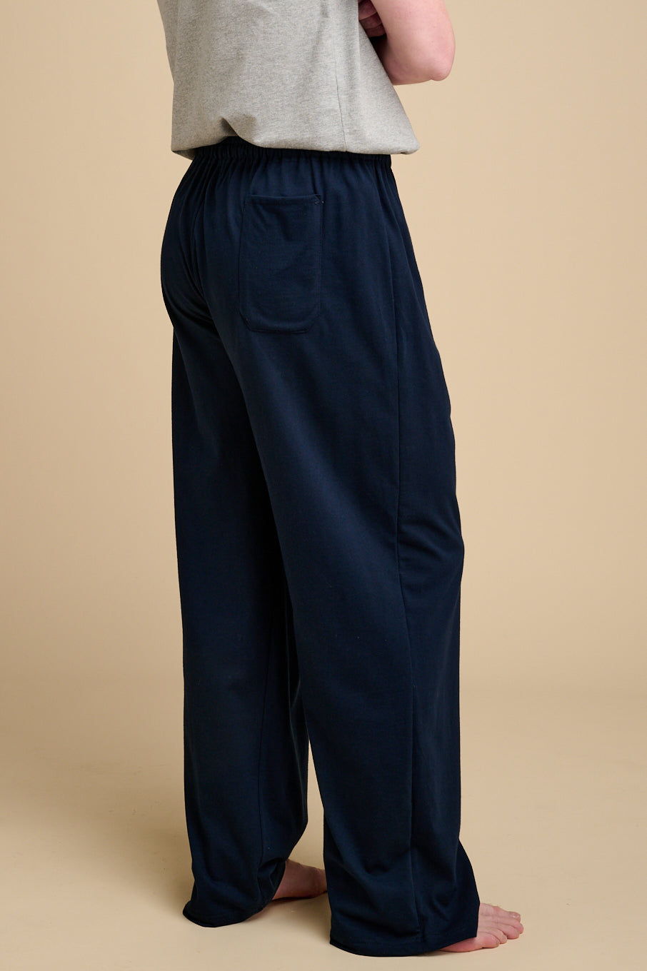 The back of man wearing navy pyjama bottoms with back pocket.