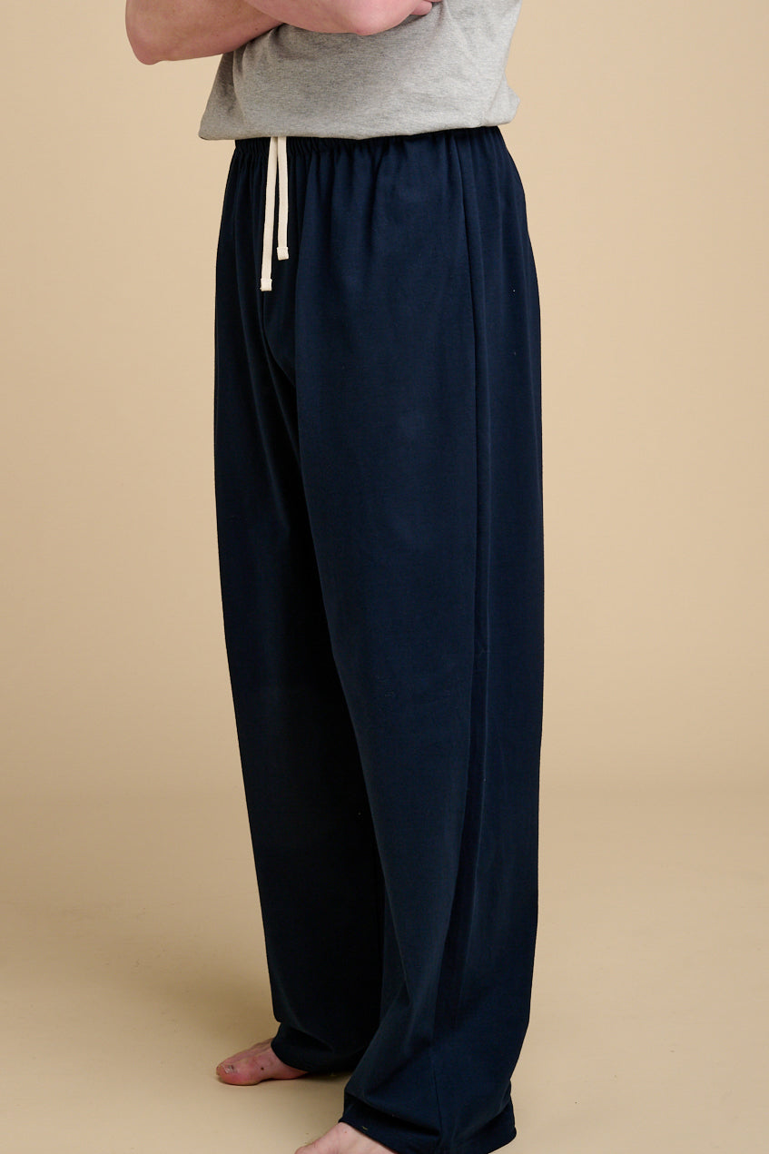 Man wearing navy pyjama bottoms with ecru drawstring