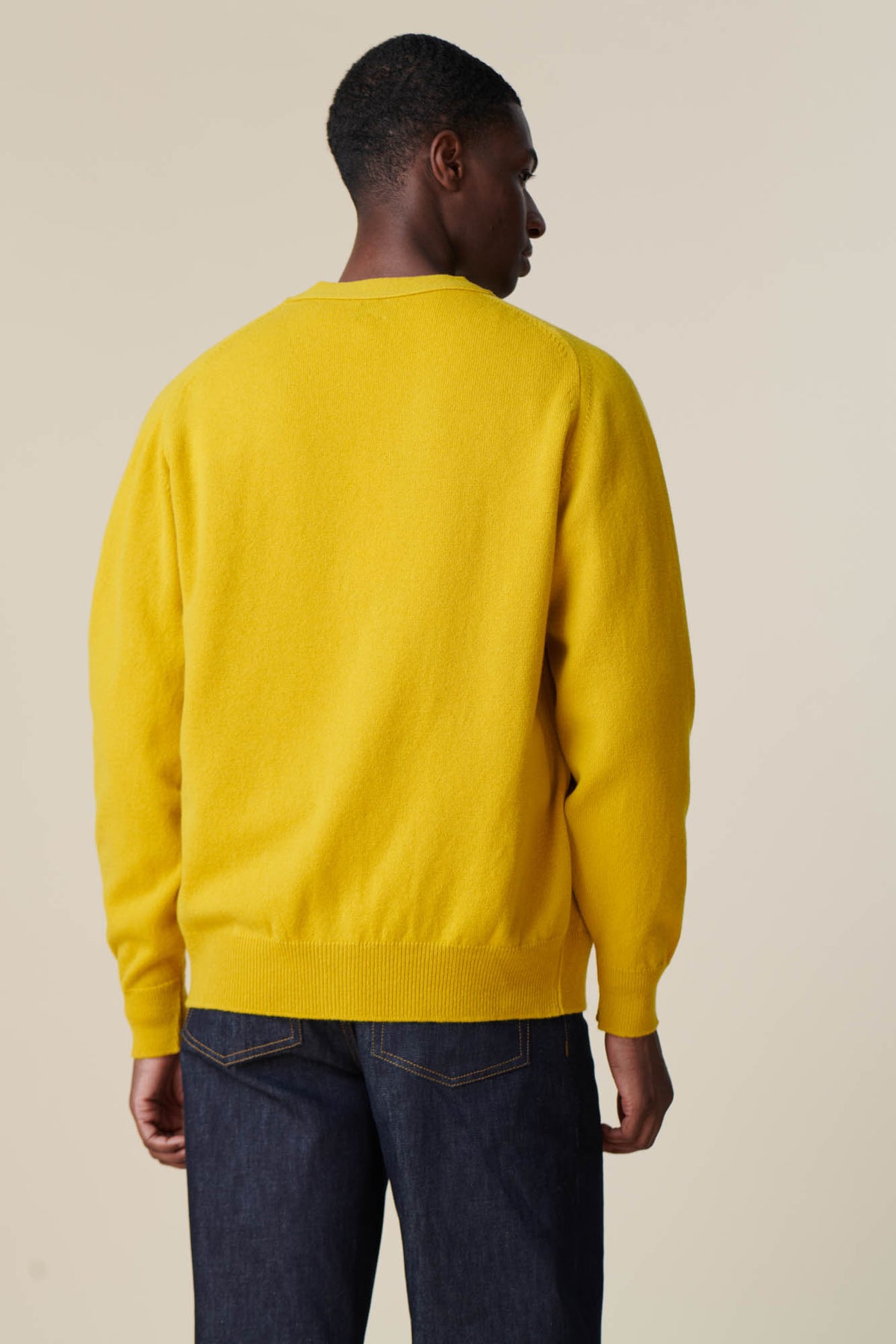 Back of male wearing lambswool cardigan in picalilli yellow