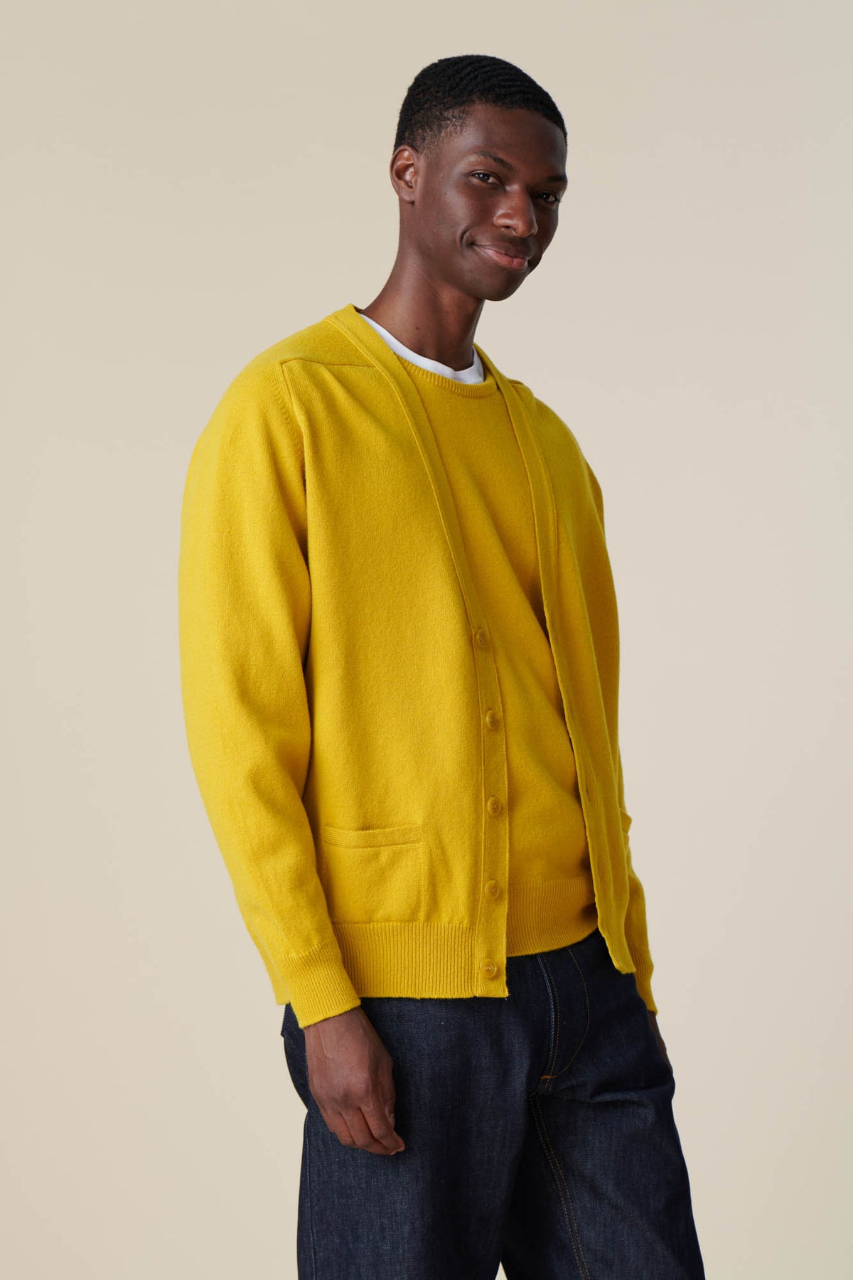 Thigh up of male wearing lambswool cardigan in picalilli yellow