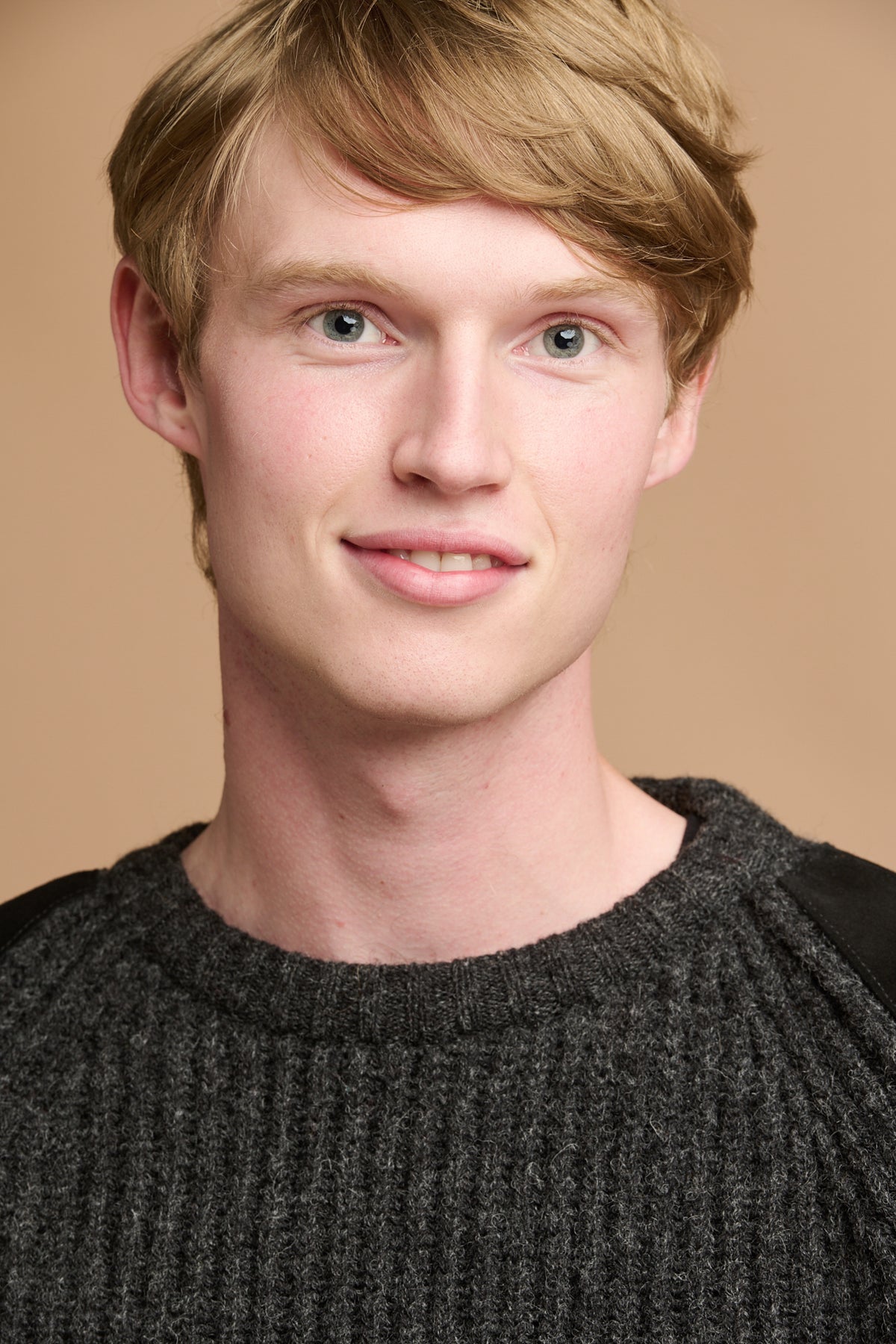 Portrait of male wearing lambswool fisherman ribbed jumper in charcoal