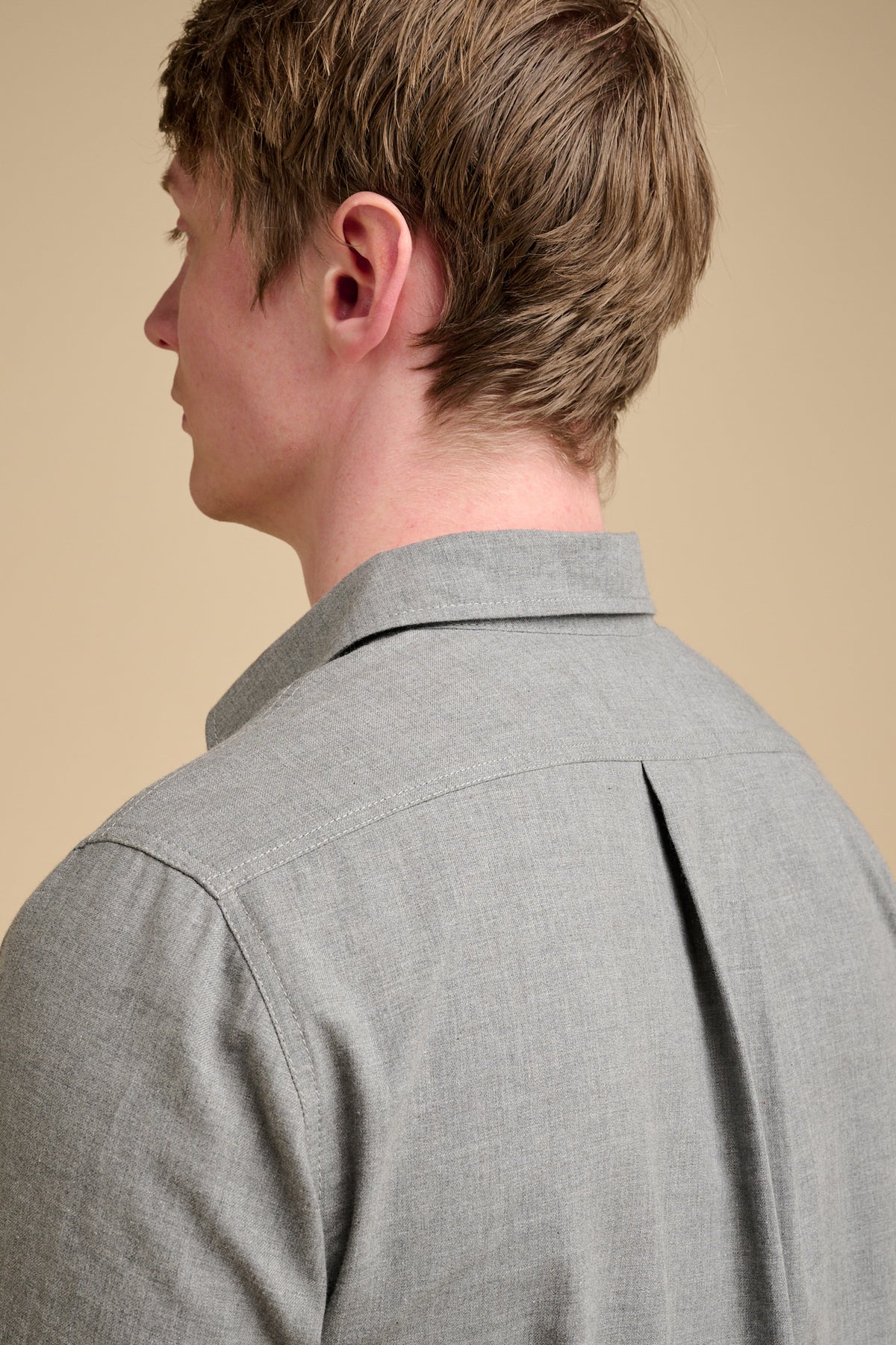 The back of man wearing grey shirt.