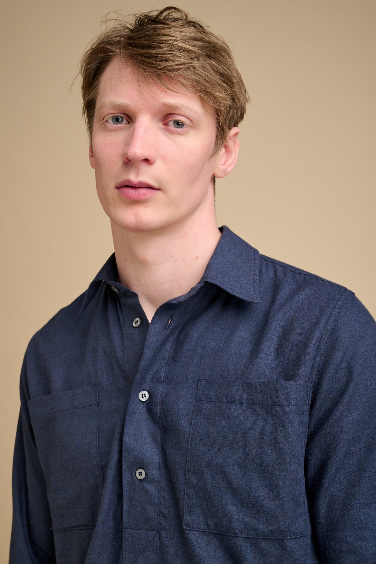 Man wearing a navy blue half placket long sleeve shirt.
