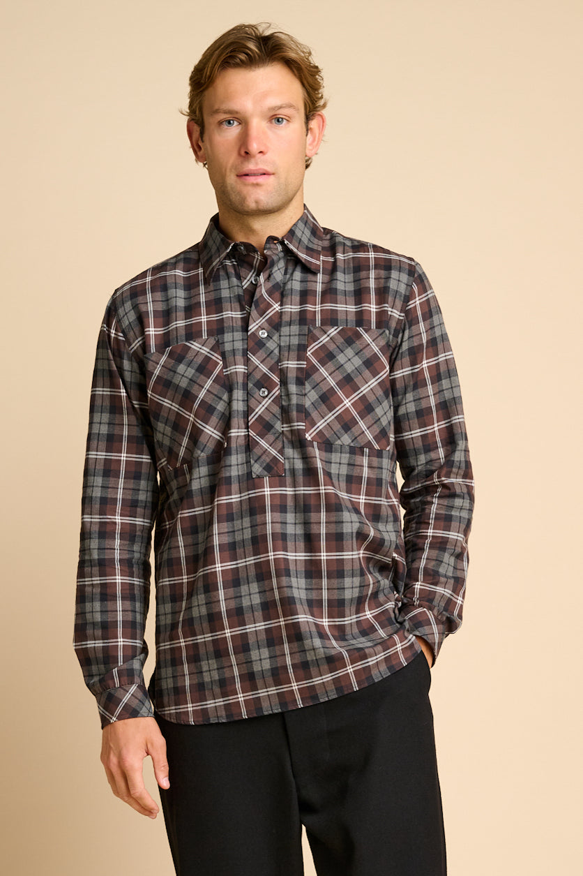 Man wearing check shirt against beieg background.