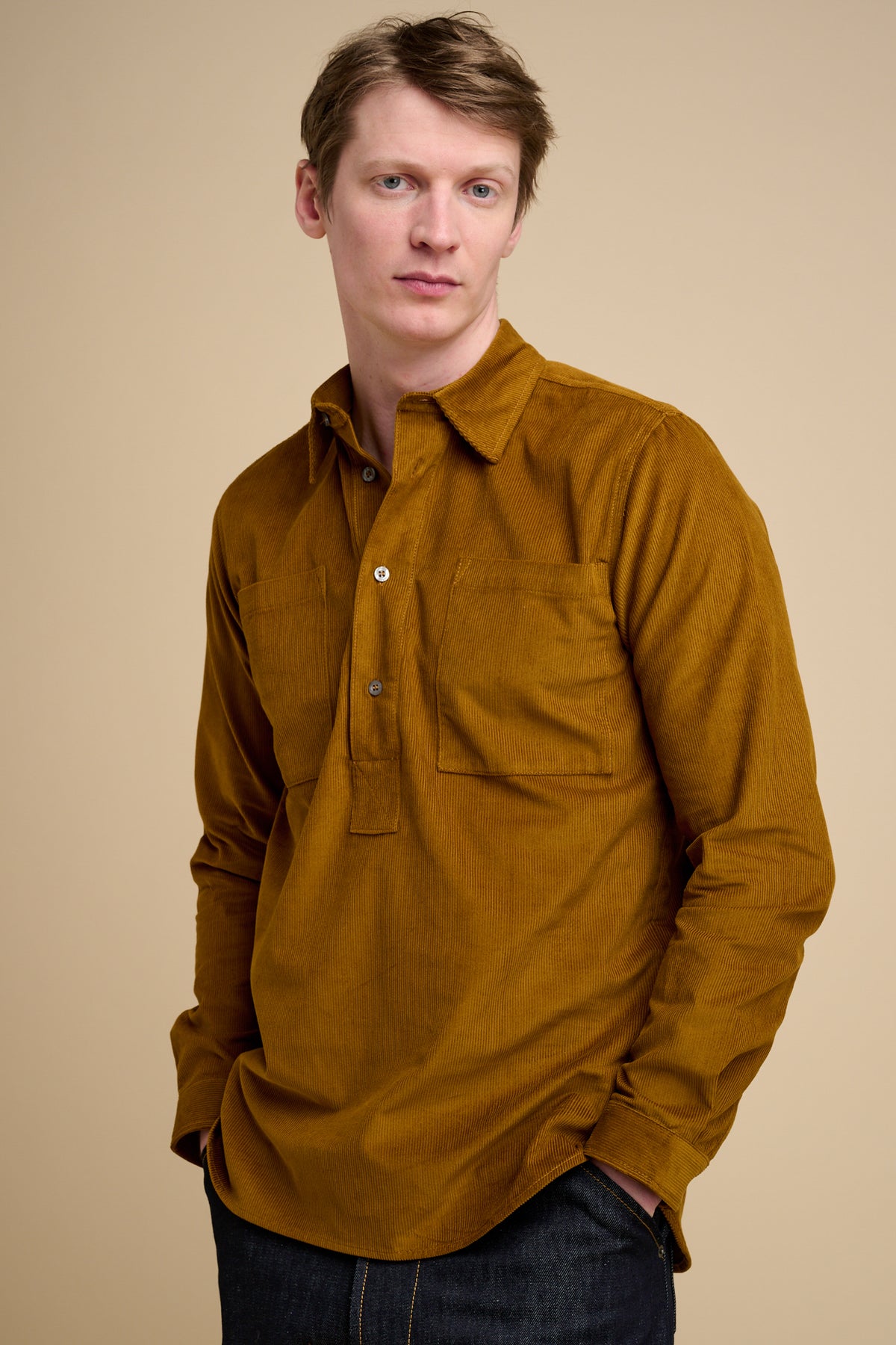 Man wearing half placket needle cord shirt in mustard.