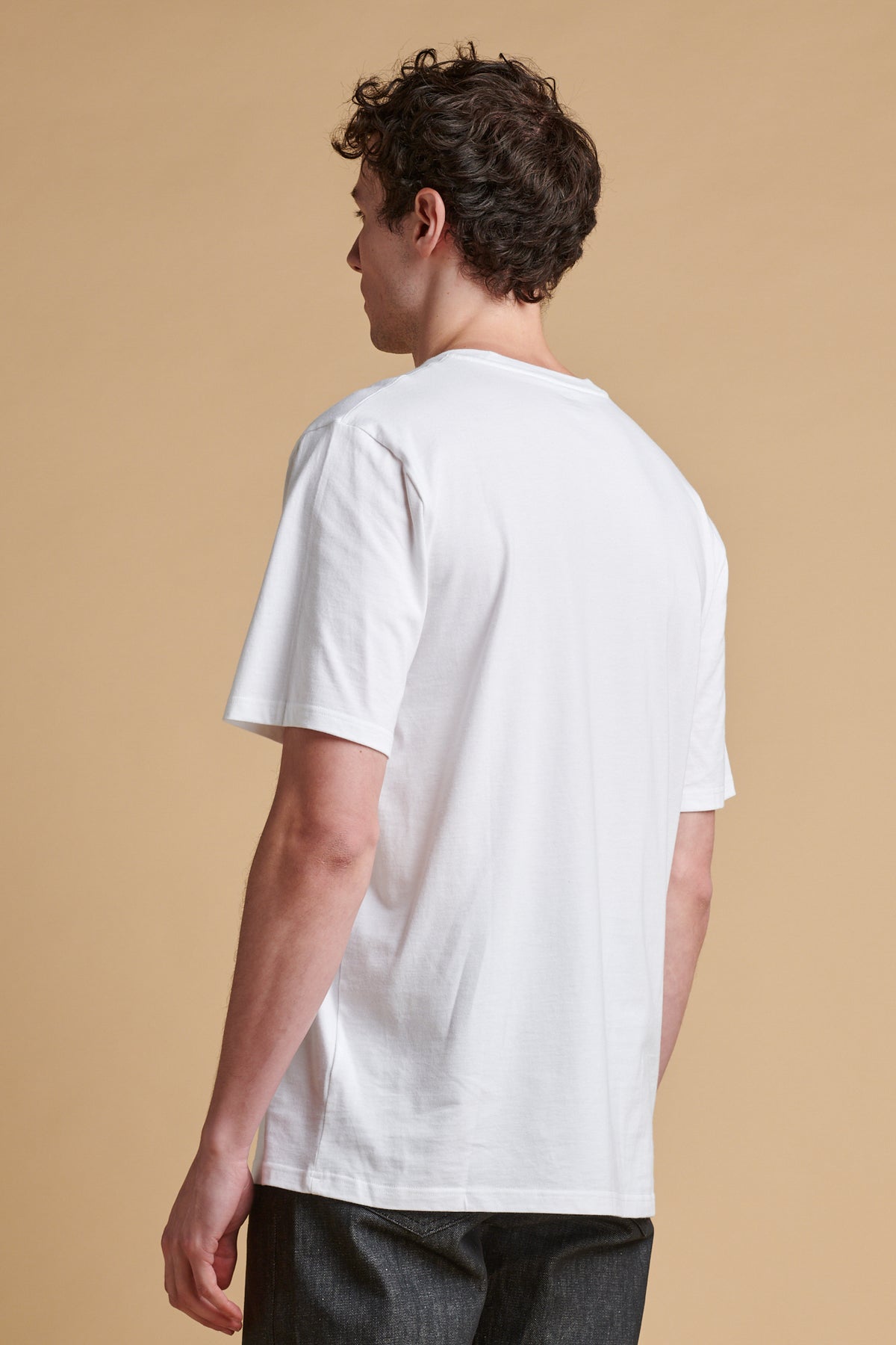 The back of male wearing short sleeve graphic t shirt.