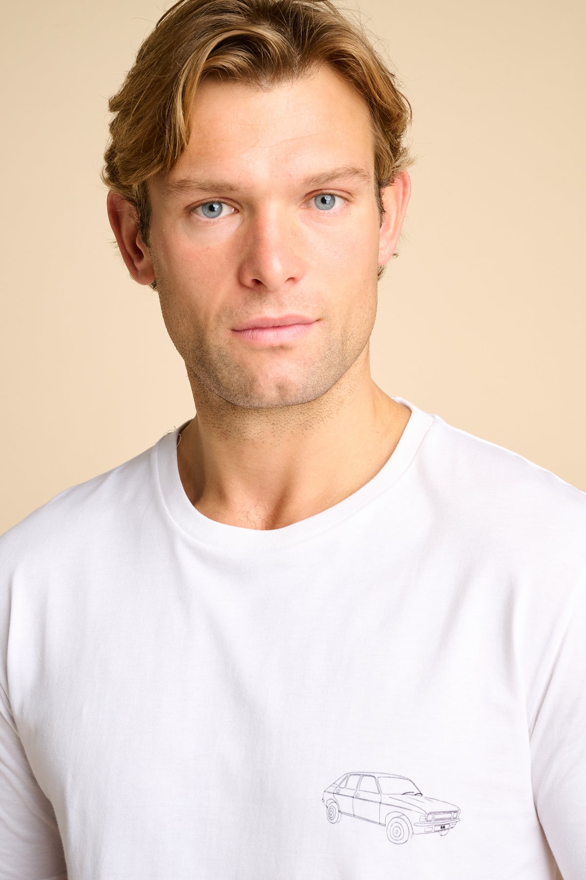 Man wearing a white t-shirt with a small graphic print.