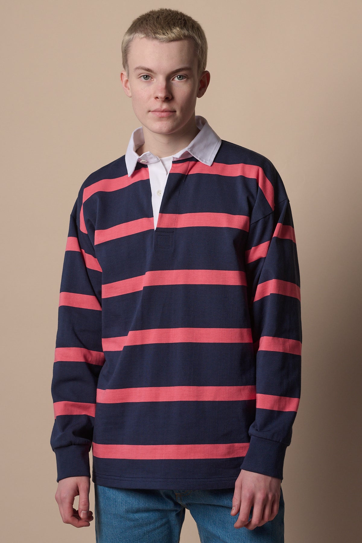 Blonde male wearing stripe rugby shirt in navy pink with white collar