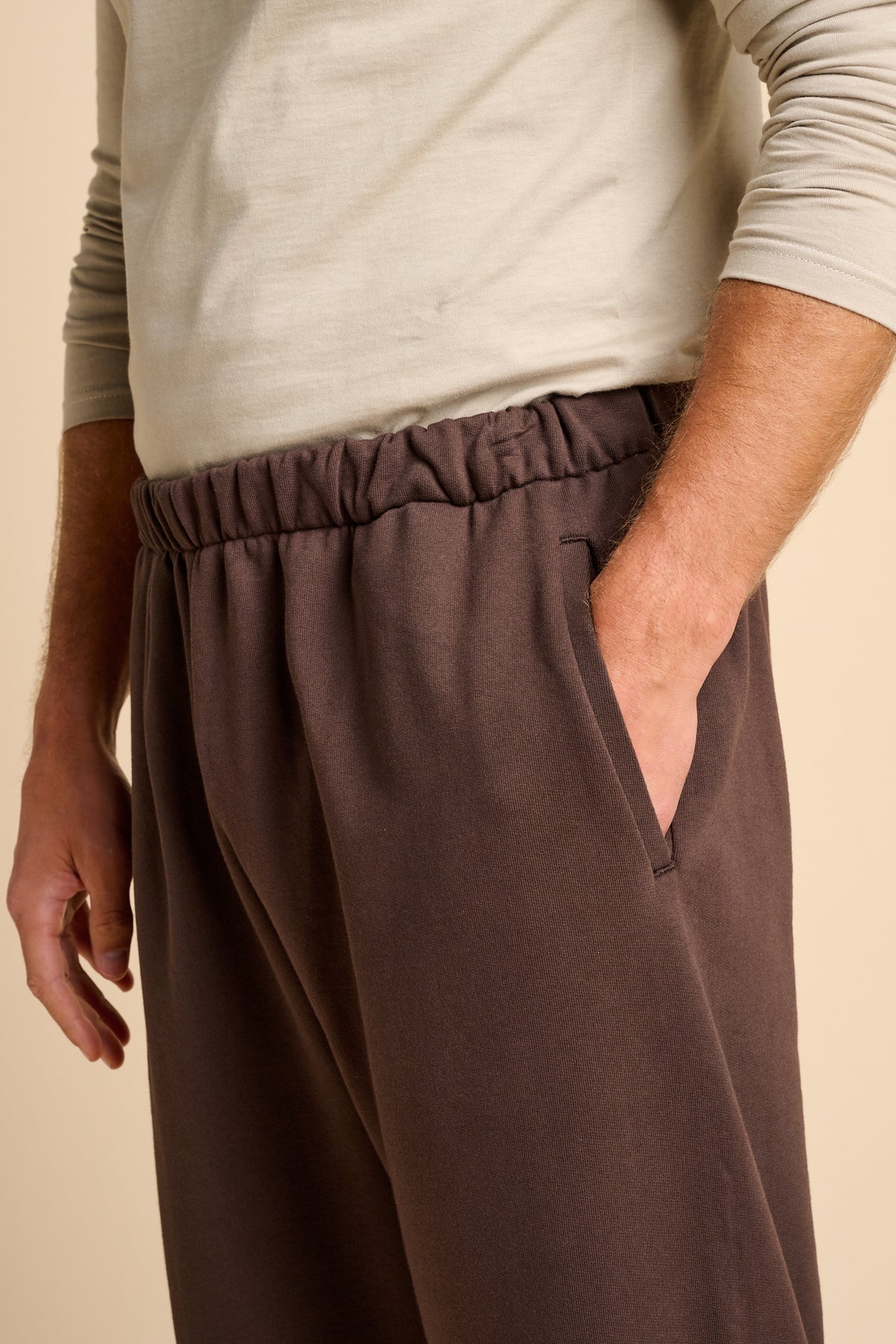 Man wearing chocolate brown sweatpants with pockets.