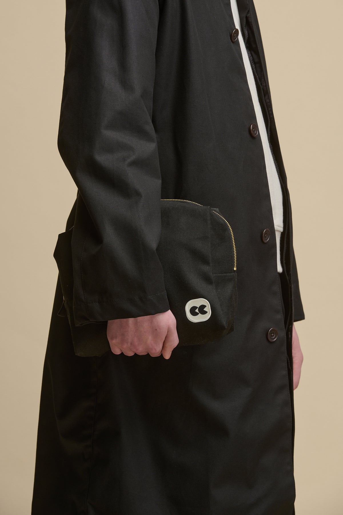 Image of male holding pouch in medium in black with CC logo patch
