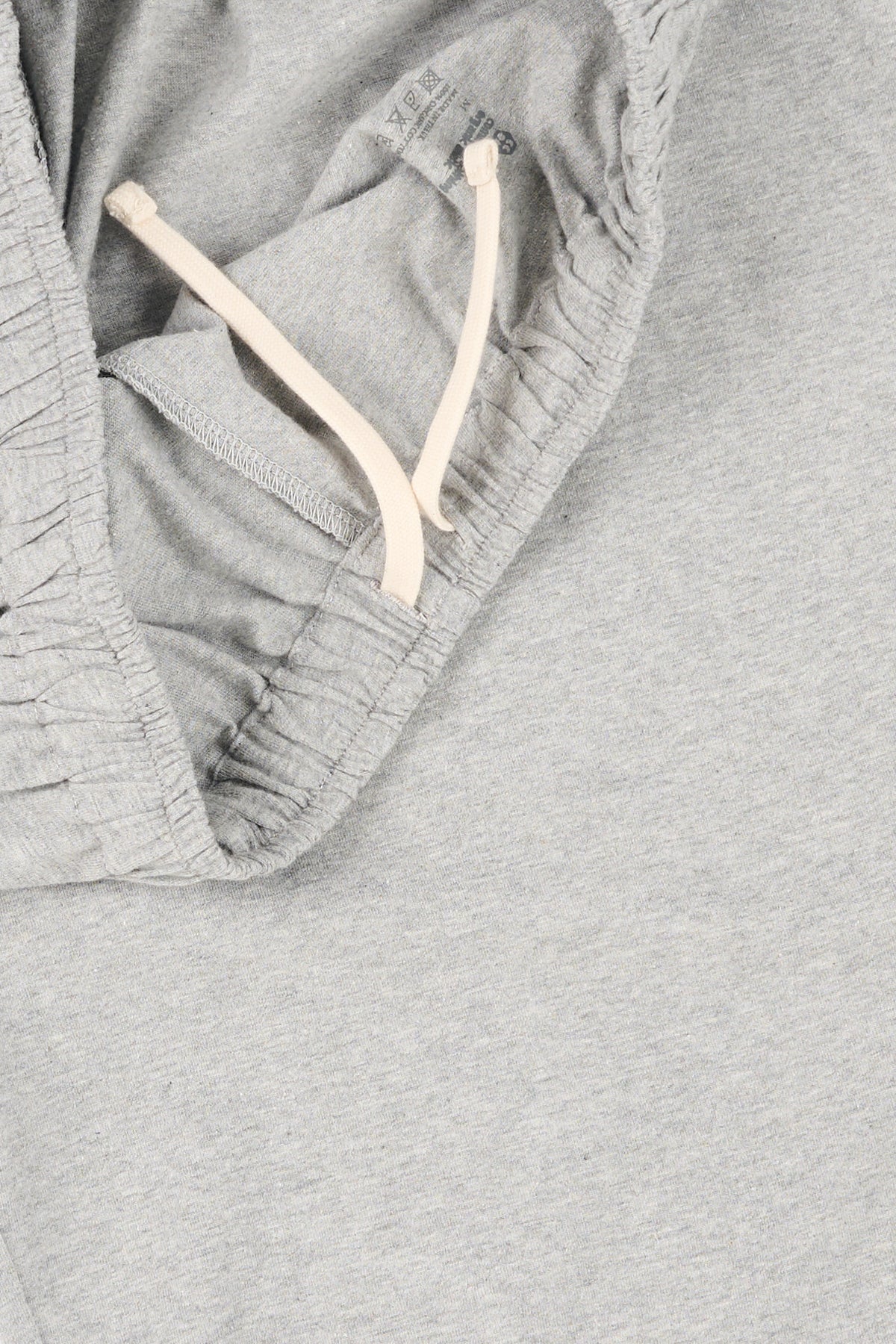 Close up of grey marl pyjama bottoms with ecru drawcord.