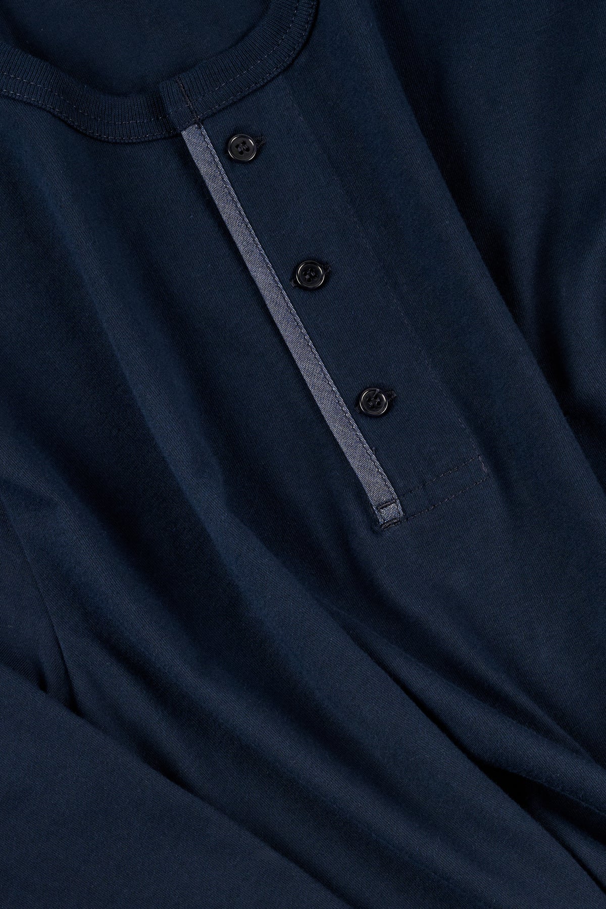 Close-up of a navy blue henley top with buttons