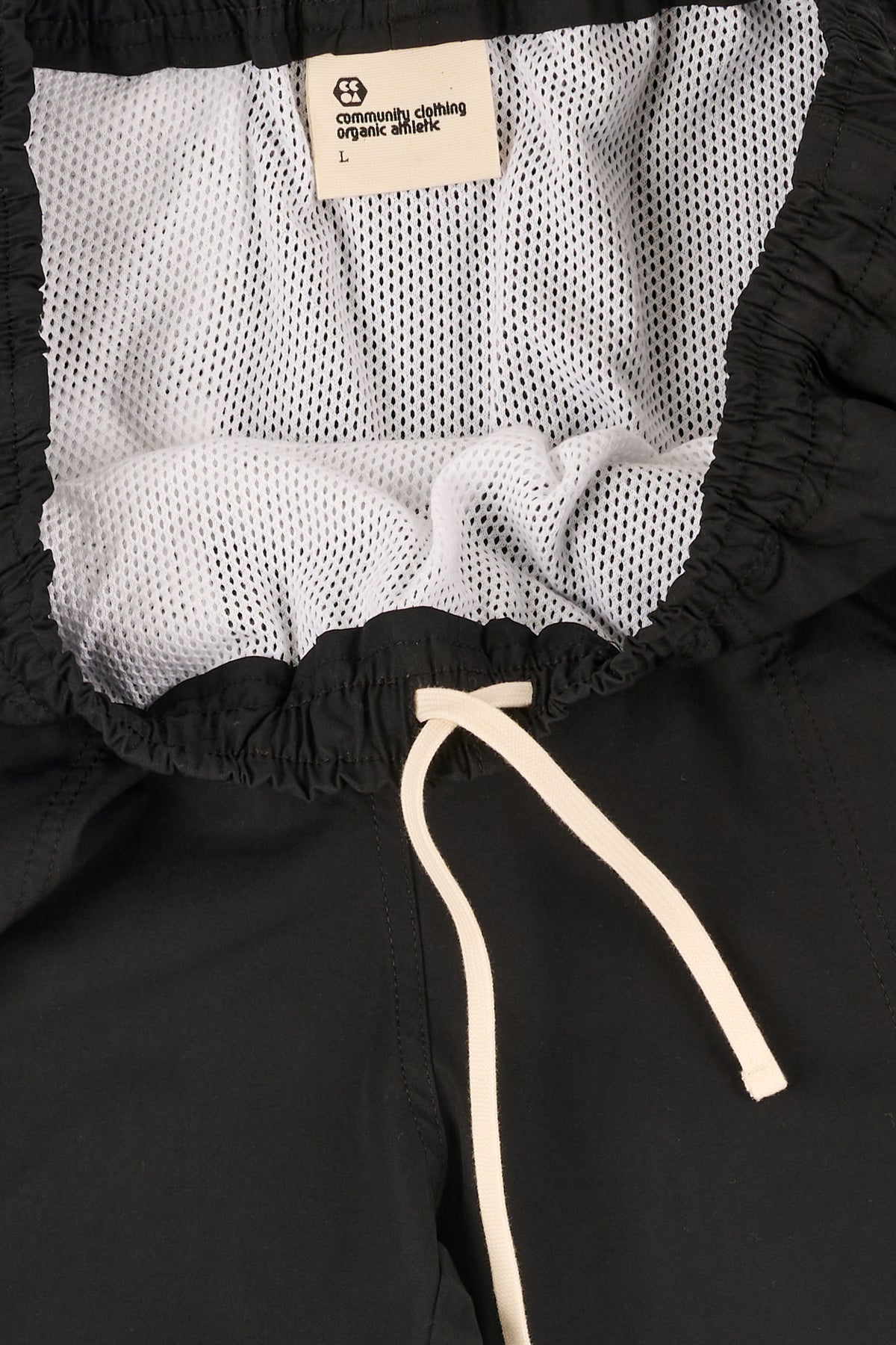 Close-up of a black shorts with an ecru drawstring.