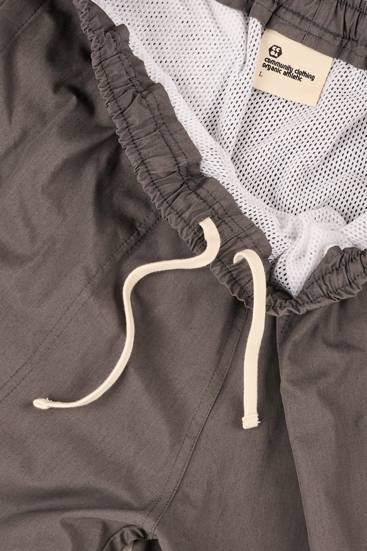 Close-up of dark grey pants with an ecru drawstring