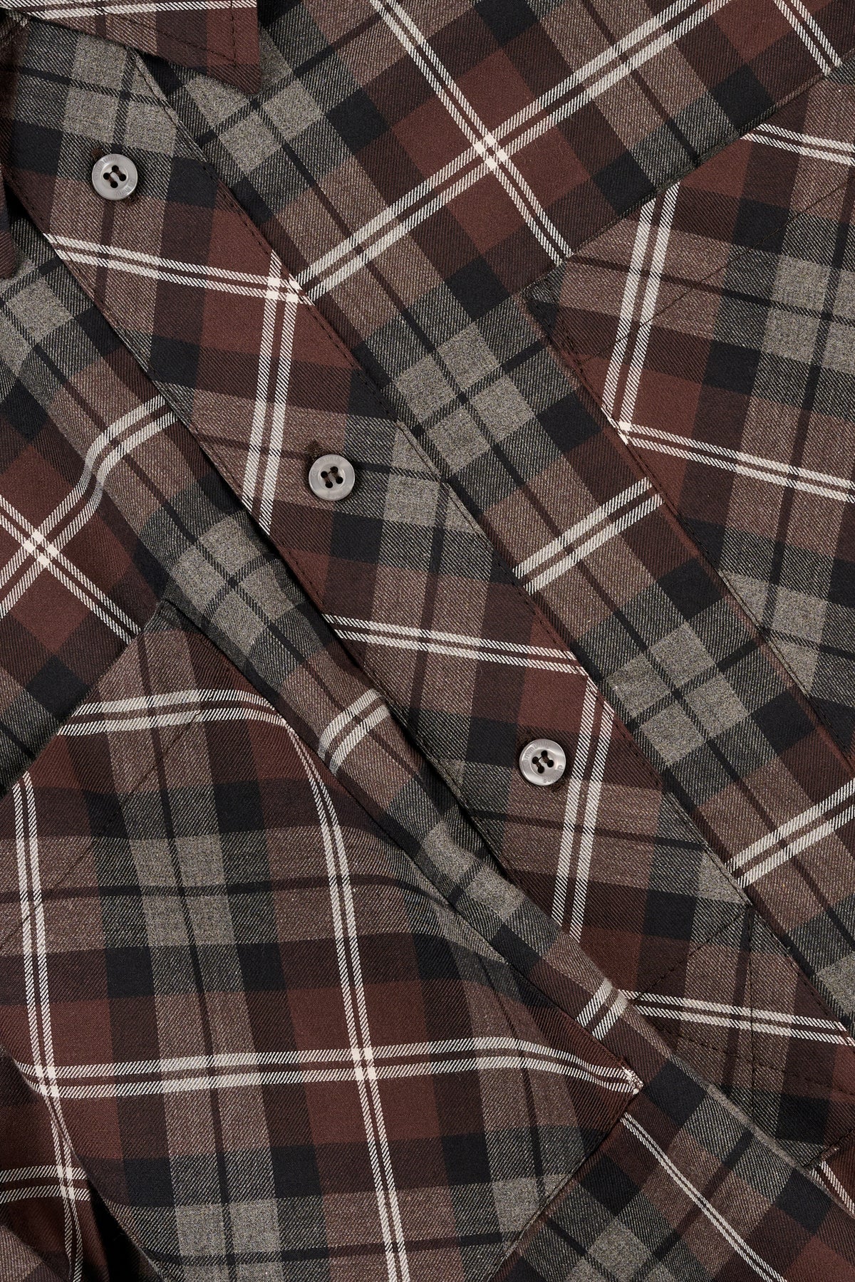 Close-up of a check shirt with brown, grey, and white.