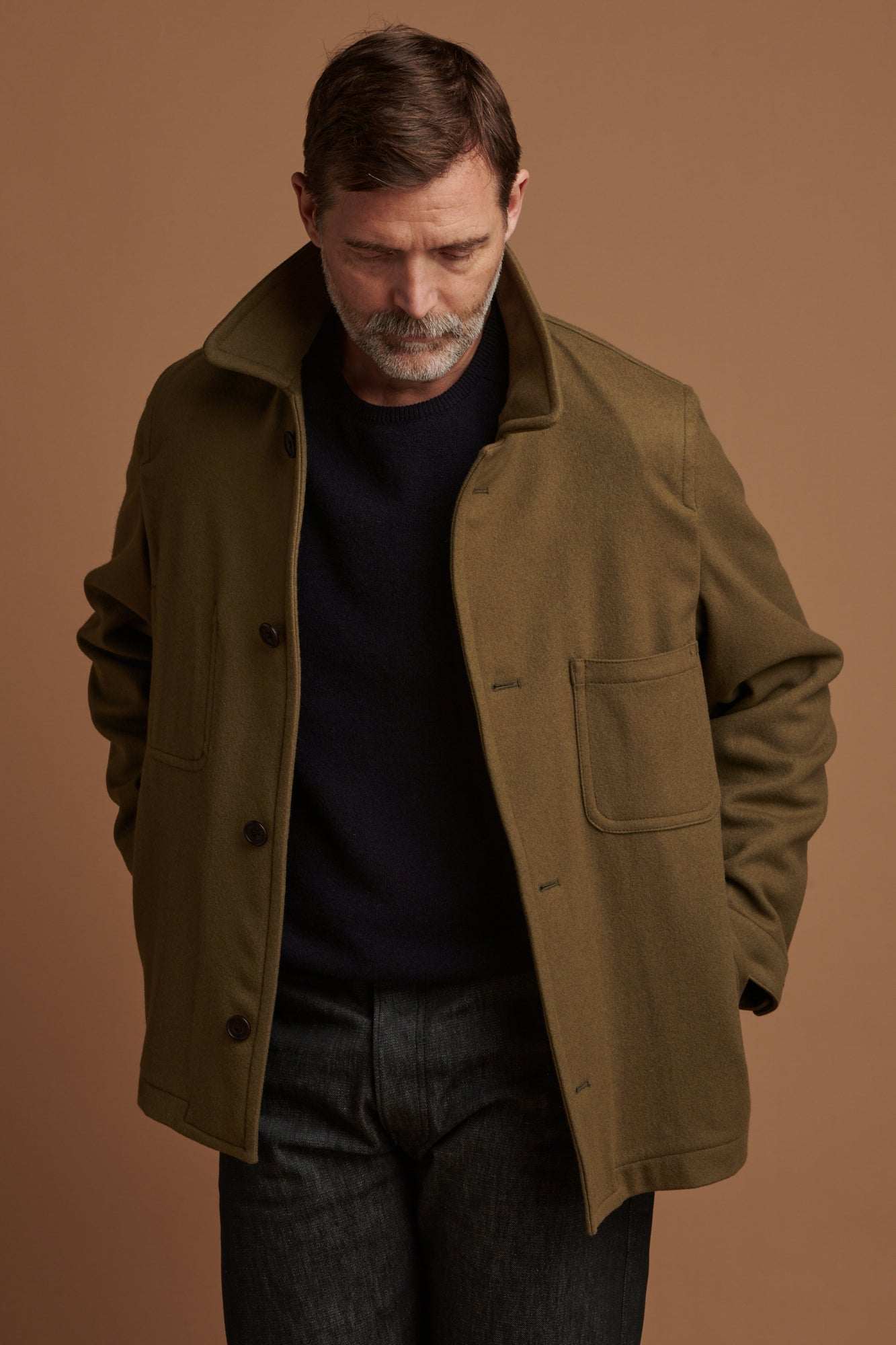 Patrick Grant wearing Community Clothing    Arthur wool chore jacket in olive with the collar up. Worn over lambswool saddle shoulder crew neck in navy.