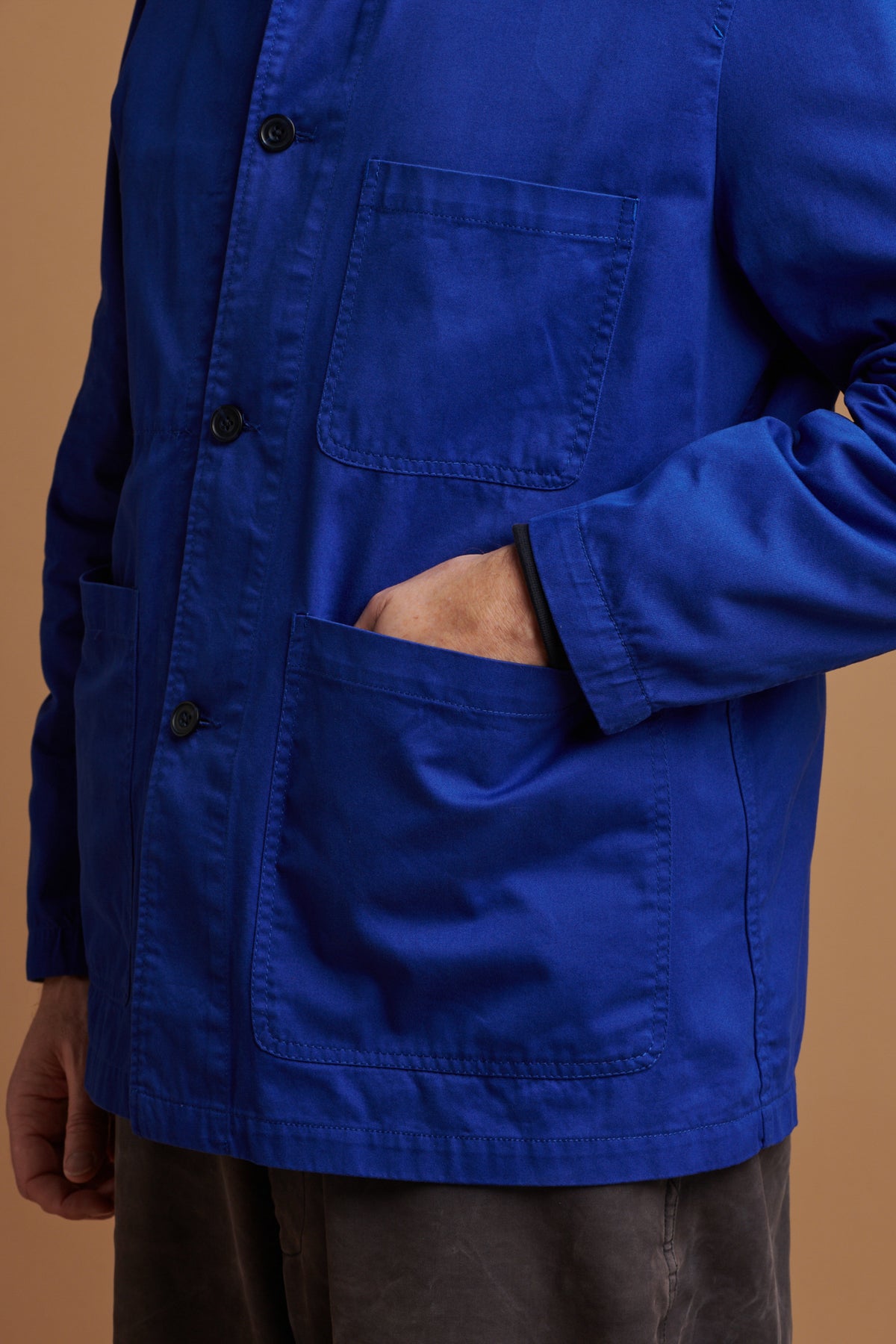 Close up of front pockets of chore jacket in royal blue