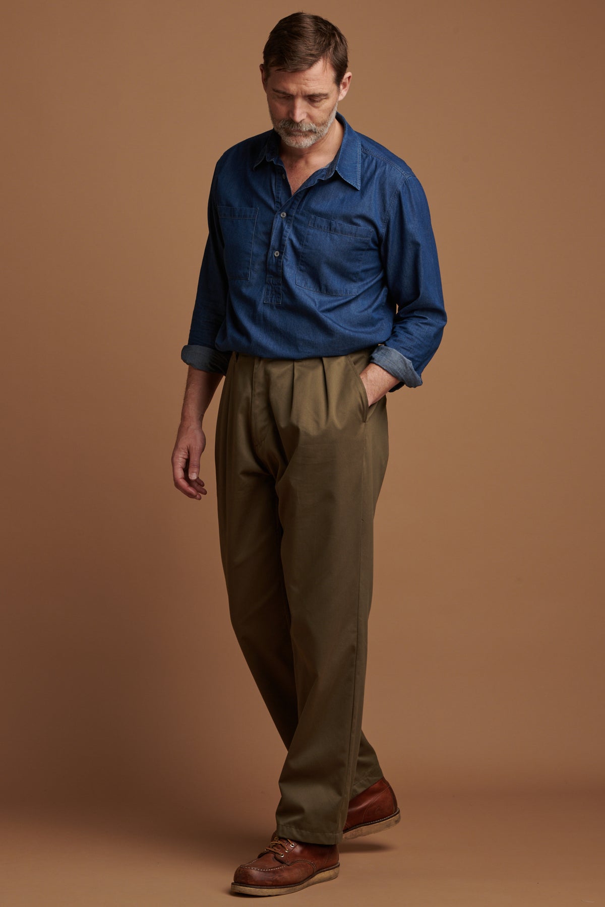 The front of Patrick wearing pleated cotton chino in olive