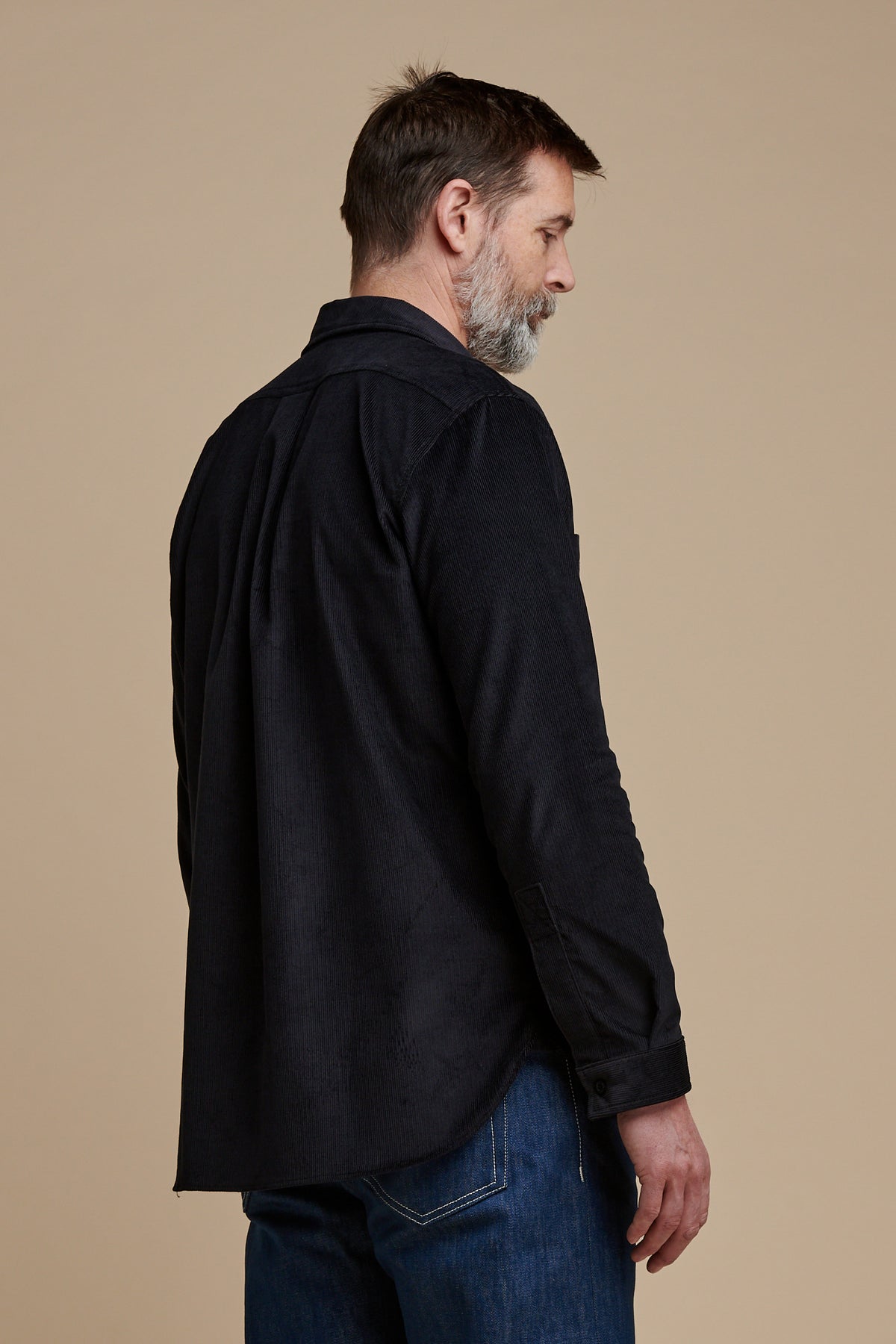 The back of Patrick in Oli half placket needle cord shirt in navy.