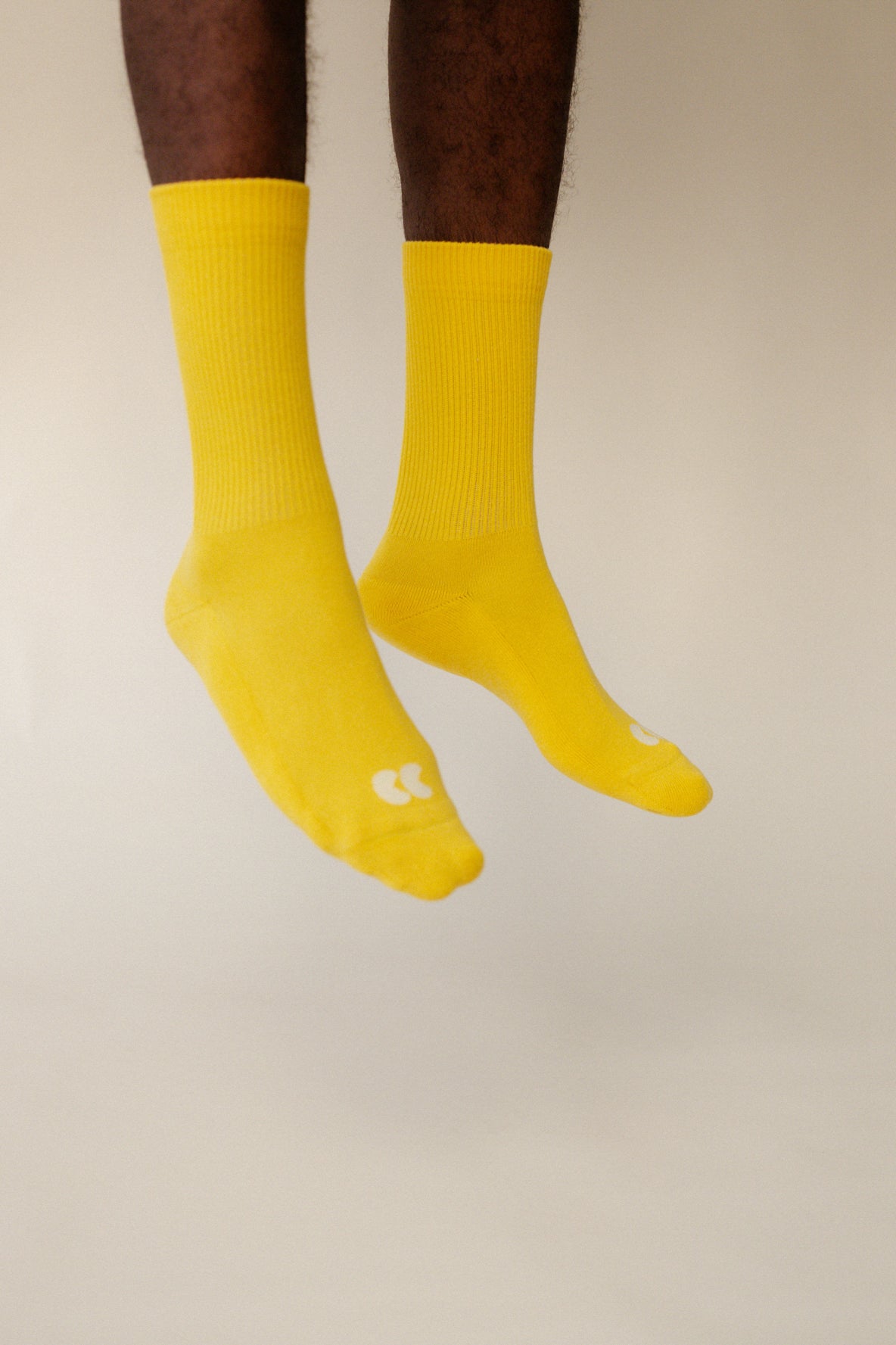 male legs mid jump wearing unisex sports calf sock in canary yellow