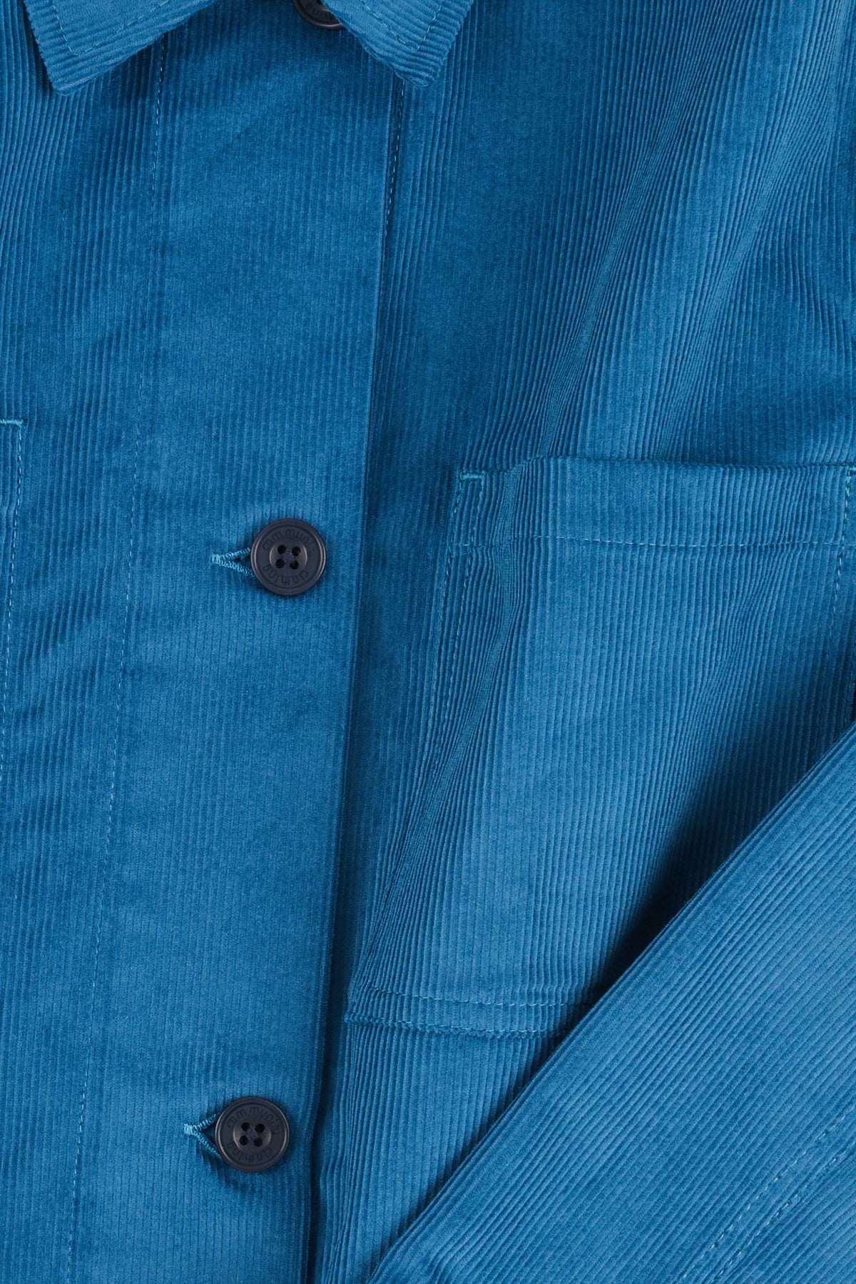 Close-up of a blue corduroy shirt with buttons and a pocket.