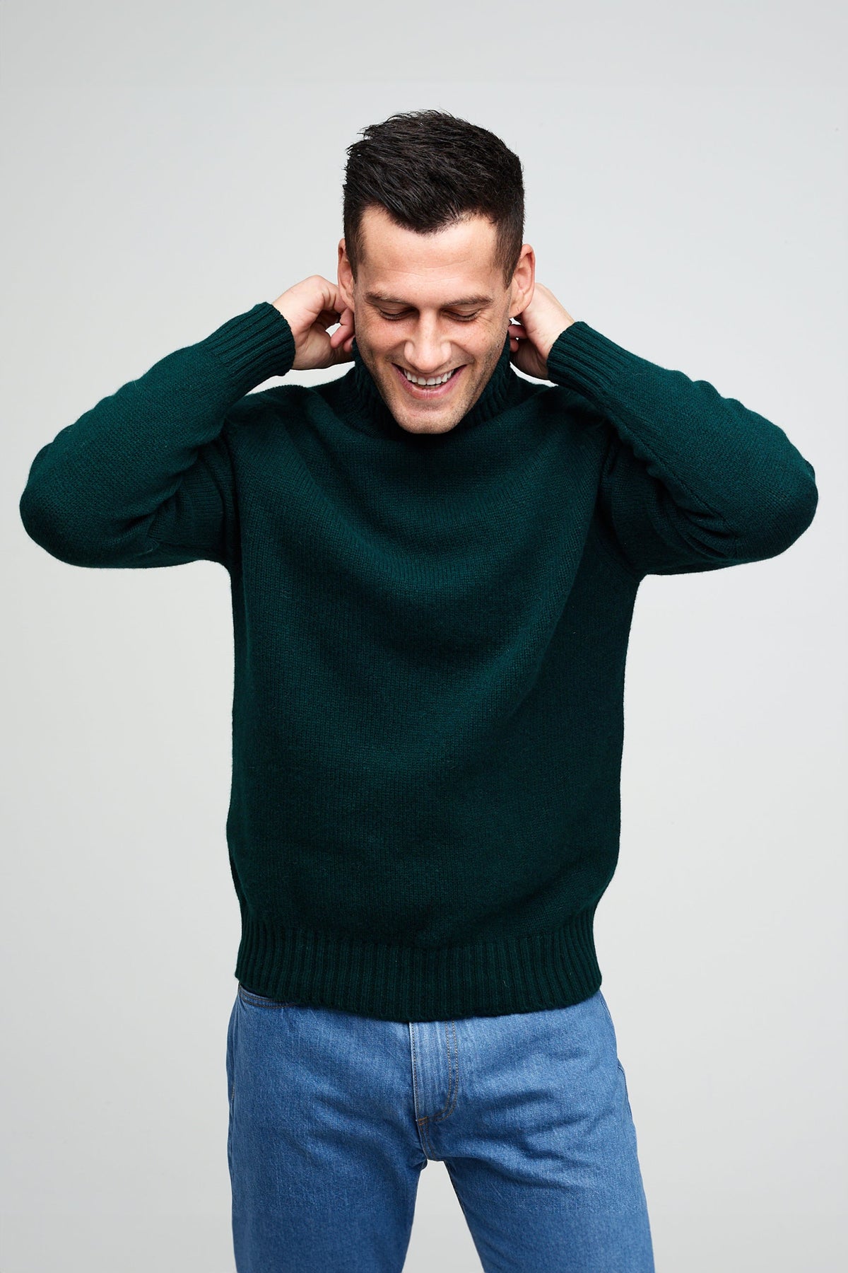 Man wearing a bottle green roll neck jumper